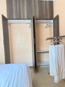 a bedroom with a sliding door and a towel rack at Fairview apartments in Wote +2 photos