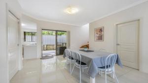a dining room with a table and some chairs at Anne Street Grand Oasis in Port Macquarie