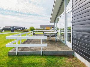 a wooden deck with a table and a bench on a house at 6 person holiday home in Sydals in Sarup