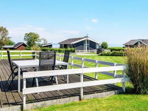 a white table and chairs next to a fence at 6 person holiday home in Sydals in Sarup