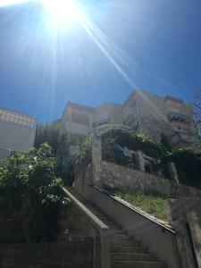 een gebouw met de zon die over een trap schijnt bij Apartments Popović in Budva