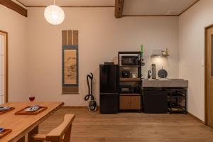 a living room with a table and a kitchen at HidaTakayama MIYABI in Takayama