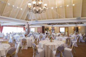 a large banquet hall with white tables and chairs at Caravelle Resort in Myrtle Beach