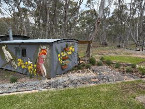 a small shed with a chicken painted on it at Prospectors Rest in Maldon