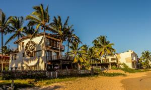 a house on the beach with palm trees at Casa Baronesa Waterfront Villa in Puerto Villamil