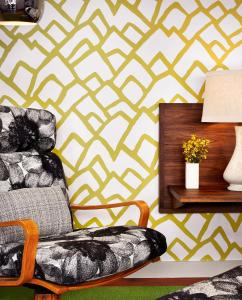a living room with a chair and a geometric wallpaper at Heywood Hotel in Austin