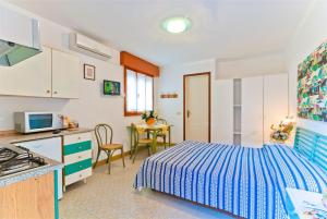 a kitchen and a bedroom with a bed and a table at Ca'Costanza in Bibione