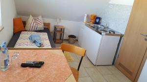 a small room with a small bed and a sink at Pension Assmann in Langenbruck