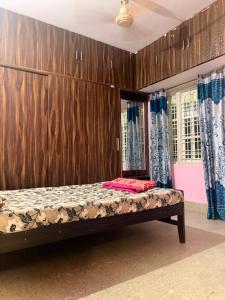 a bed in a room with a wooden wall at The Green residence in Mysore