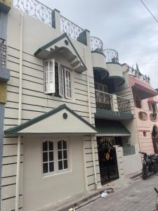 a large white building with a balcony at The Green residence in Mysore