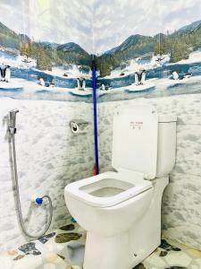 a bathroom with a toilet and a painting of penguins at New Forest Glen Nest in Ella