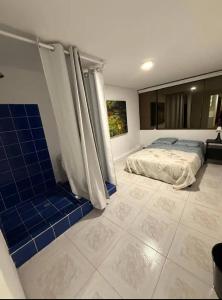 a bedroom with a bed and blue tile floors at Aparta estudios enceguida Hotel intercontinental in Cali