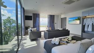 JBAY Beachfront Boutique Hotel في دا نانغ: غرفة نوم مع سرير وغرفة معيشة