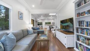 a living room with a couch and a tv at Diamond Escape - Pearl in Umina