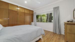 a bedroom with a large bed and a window at Diamond Escape - Pearl in Umina +11 photos
