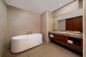a bathroom with a large tub and a sink at Wuxi Winterless Hotel in Wuxi +14 photos