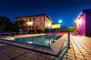 een zwembad 's nachts met een resort bij Agriturismo Bianconiglio in Monforte dʼAlba