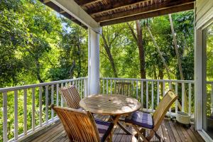 ヌーサヘッズにあるTropical Family Hideaway, Noosa Headsの木製のテーブルと椅子が置かれたポーチ