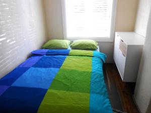 a bed with a colorful blanket in a room at Yellow Center Holiday Home in Pärnu
