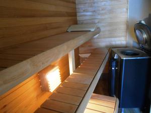 a small sauna with a wooden floor and a stove at Yellow Center Holiday Home in Pärnu +6 photos