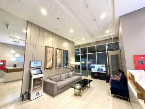a woman sitting on a couch in a living room at Heart of CDO Scenic View in Cagayan de Oro