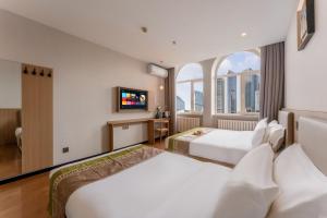 een hotelkamer met twee bedden en een tv bij Zhongmai Yunting Hotel in Harbin