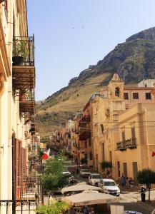 Eine Stadtstraße mit Gebäuden und einem Berg im Hintergrund in der Unterkunft Case D'Anna in Castellammare del Golfo