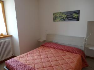 a bedroom with a bed with a pink comforter at Casa Elisa in Pietramurata