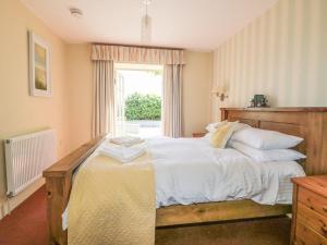 a bedroom with a bed with white sheets and a window at Foxes Den in Saint Goran