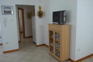 a tv sitting on top of a wooden cabinet at Casa Elisa in Pietramurata