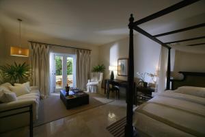 a bedroom with a bed and a living room at Casa Colonial Beach & Spa in San Felipe de Puerto Plata
