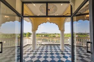 a balcony with glass doors and a checkerboard floor at Umrao Mahal - A Boutique Heritage Hotel & Resort Jaipur in Jaipur