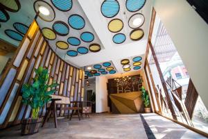 卡兰古特HALF Hotel, Calangute的走廊设有窗户和桌椅