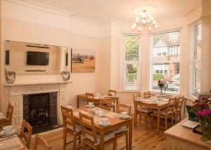 a dining room with a fireplace and tables and chairs at The Guest House Broadstairs in Broadstairs