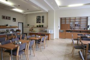 a restaurant with wooden tables and chairs and a kitchen at City-Pension Magdeburg in Magdeburg