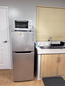 a kitchen with a microwave on top of a refrigerator at 2BR Condo at Sanremo with Full Kitchen plus Free Fast&Unli Wi-Fi Complimentary Netflix plus Free Access to Pool in Cebu City