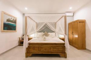 a bedroom with a canopy bed with white sheets at Modern Villa heart of Canggu in Canggu