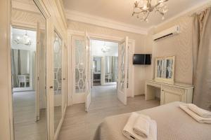 una camera da letto bianca con un letto e uno specchio di Vila Cornelia a Bucarest Altre 58 foto