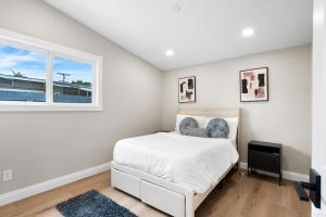 a white bedroom with a bed and a window at Xlnc Exotic home Rexview Dr in San Diego