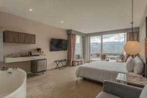 a bedroom with a tub and a bed and a bathroom at V Grand Hotel, a member of Radisson Individuals in Medellín +135 photos