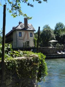 une maison assise sur le bord d'une rivière dans l'établissement Moulin de la Chevriere, à Saché