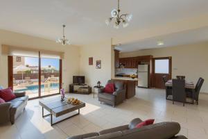 a living room with a couch and a table at Villa Cypria Maria by Villa Plus in Peyia