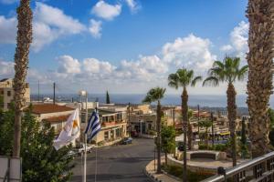 a view of a town with palm trees and the ocean at Villa Cypria Maria by Villa Plus in Peyia