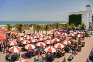 a group of tables with red and white umbrellas on the beach at Castle in the Sand in Ocean City