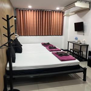 a bed in a room with two towels on it at DonMueang station hotel in Ban Don Muang (1)