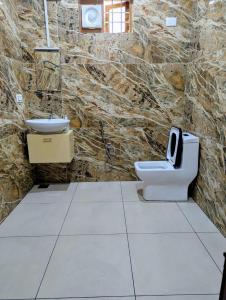 a stone bathroom with a toilet and a sink at Chithira House Tranquil Holiday Home in Alleppey