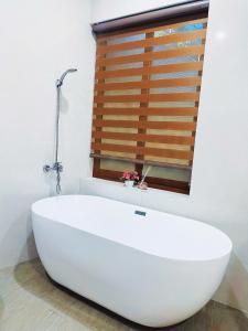 a white bath tub in a bathroom with a window at Mie's Homestay in Da Nang