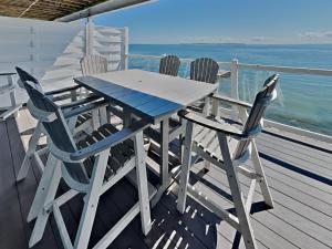 a table and chairs on a deck with the ocean at Put-in-Bay Waterfront Condo #202 in Put-in-Bay