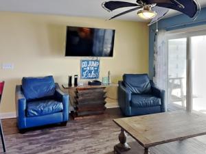 a living room with two blue chairs and a tv at Put-in-Bay Waterfront Condo #202 in Put-in-Bay +24 photos