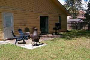 a patio with chairs and a grill in front of a house at Sunny Lemon in Middleburg